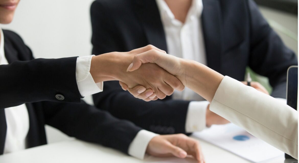 Business professionals shaking hands during a meeting to seal a partnership agreement