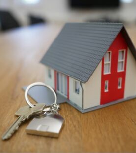 House keys beside model property on wooden table